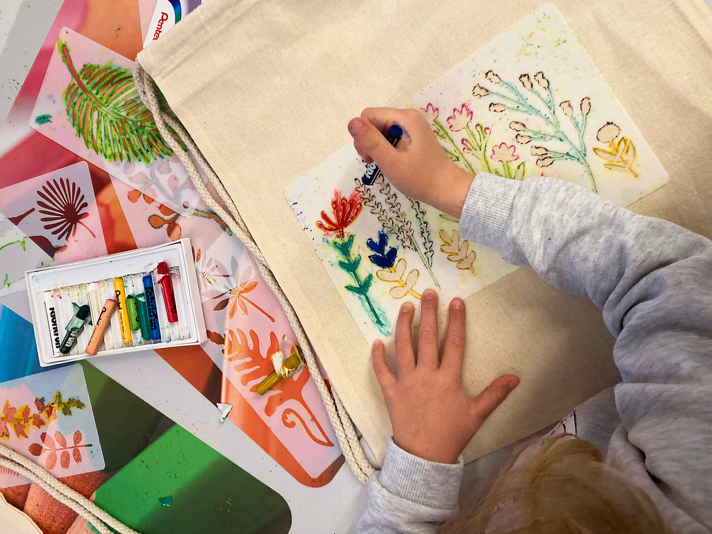 Kind malt eine bunte Stofftasche an