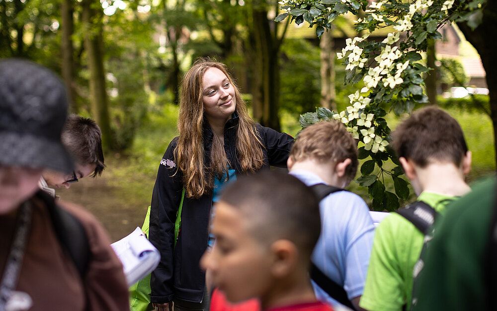 Eine Gruppe Menschen steht draußen in einem Wald