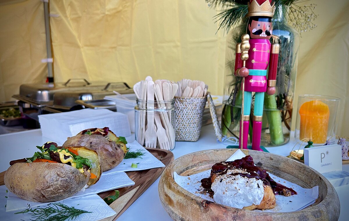 Ein Food-Stand auf dem Adventsmarkt. Zu sehen sind zwei Speisen, Kartoffeln und ein French-Toast.