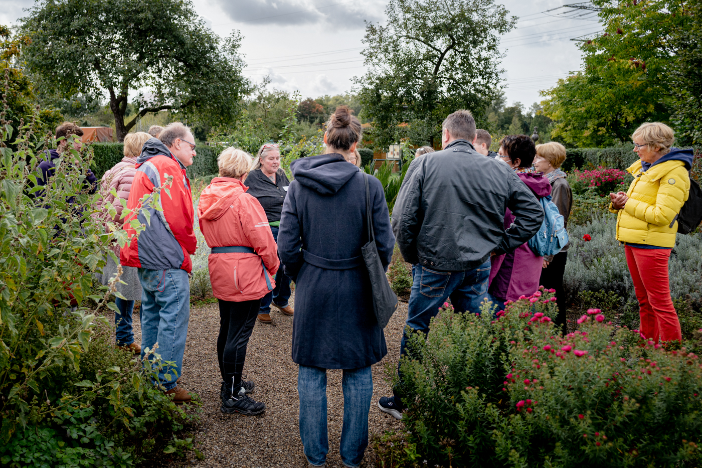 Eine Gruppe Menschen stehen bei einer Führung im Bauerngarten