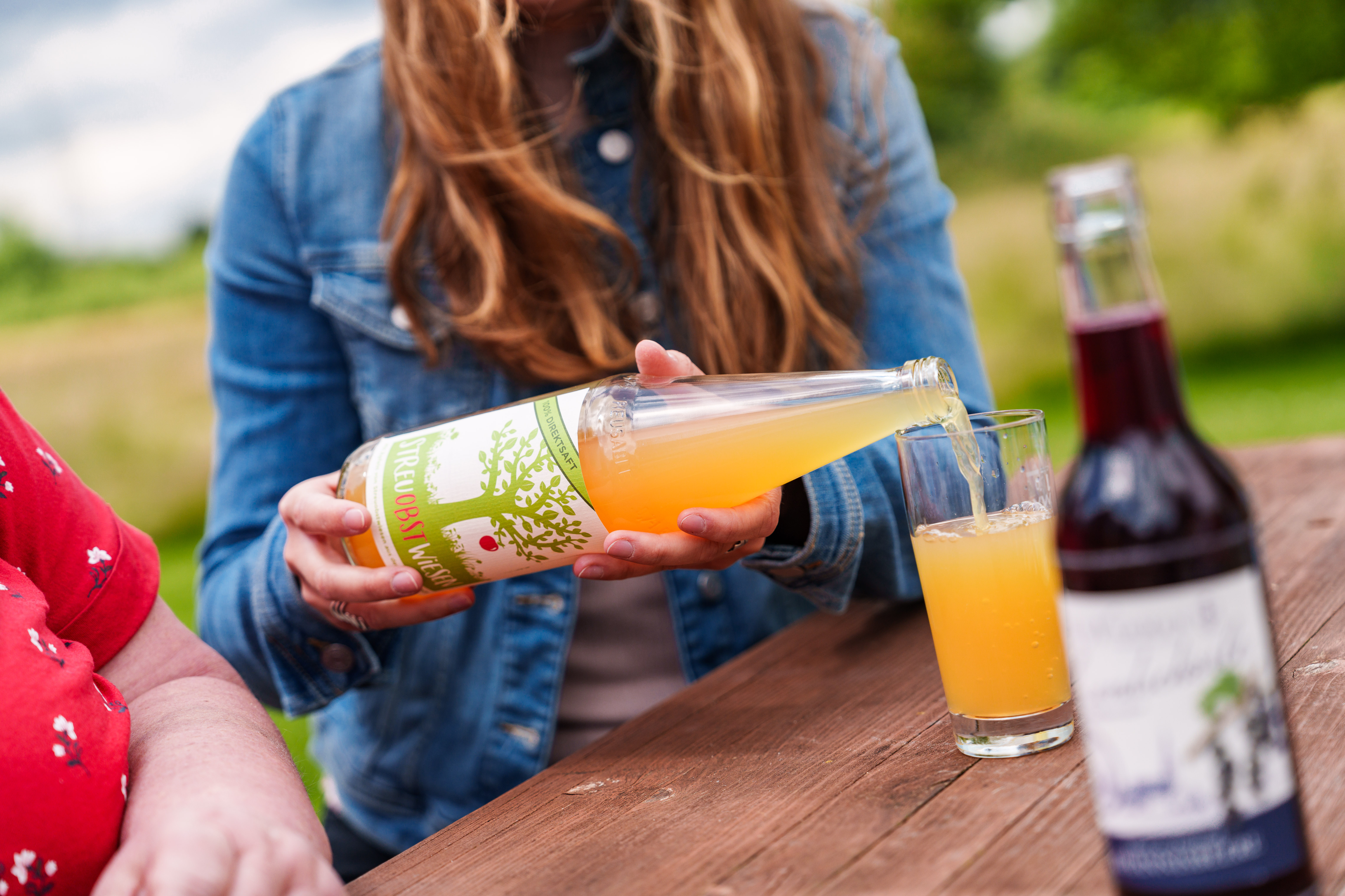Eine Person schüttet sich Saft in ein Glas