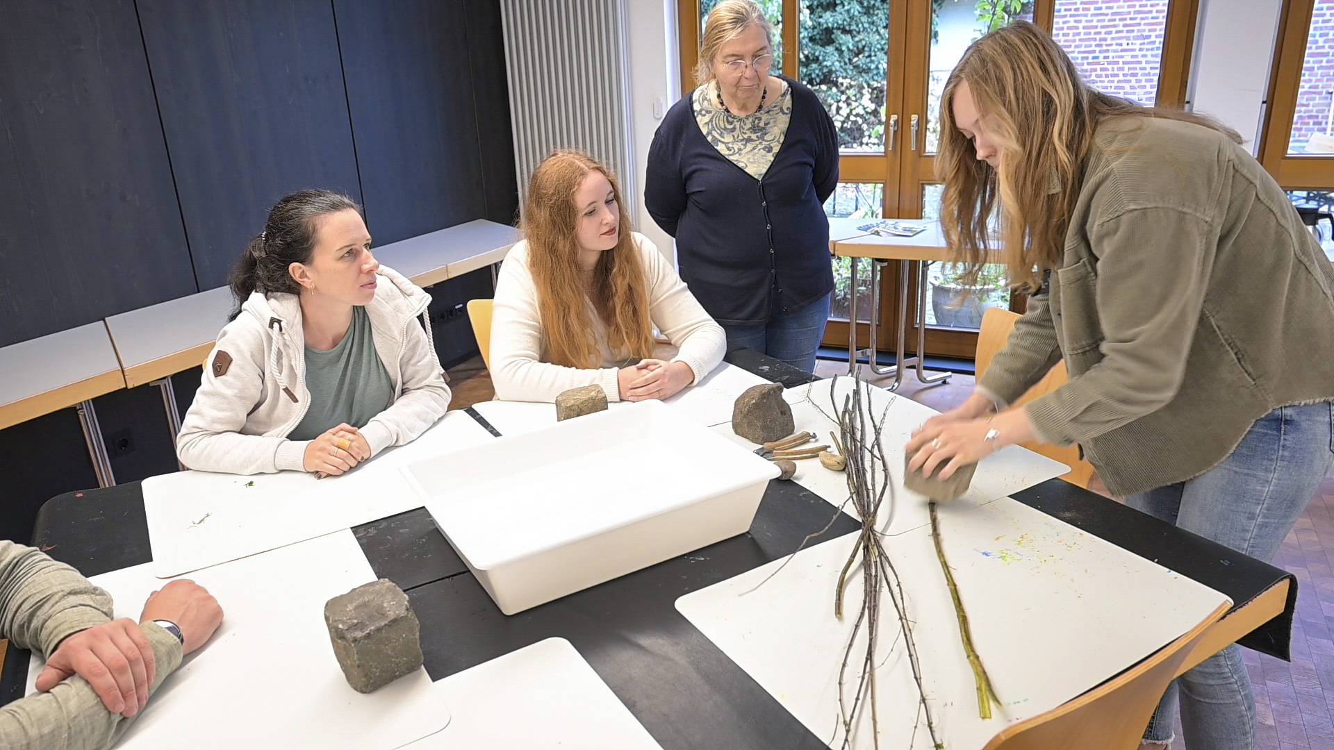 Die Kursleiterin zeigt den Workshop Teilnehmenden die Brennnessel aus der Nähe